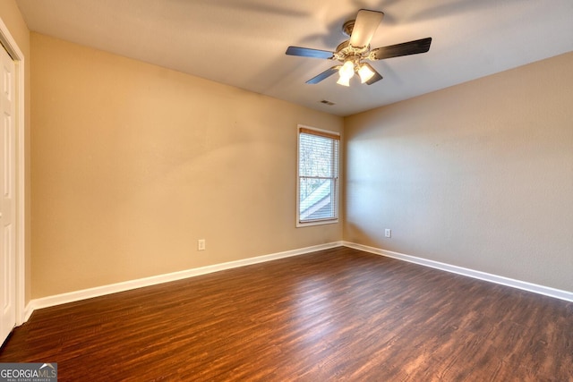 empty room featuring ceiling fan and dark hardwood / wood-style flooring