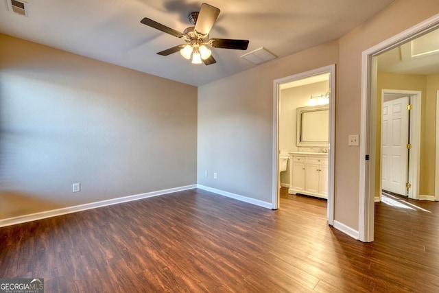 unfurnished bedroom featuring ceiling fan, ensuite bathroom, and dark hardwood / wood-style flooring