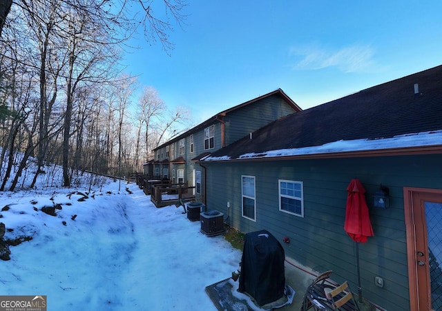 snow covered property featuring central air condition unit