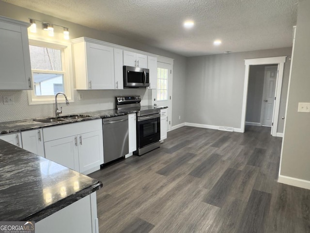 kitchen featuring dark hardwood / wood-style floors, white cabinetry, sink, stainless steel appliances, and plenty of natural light