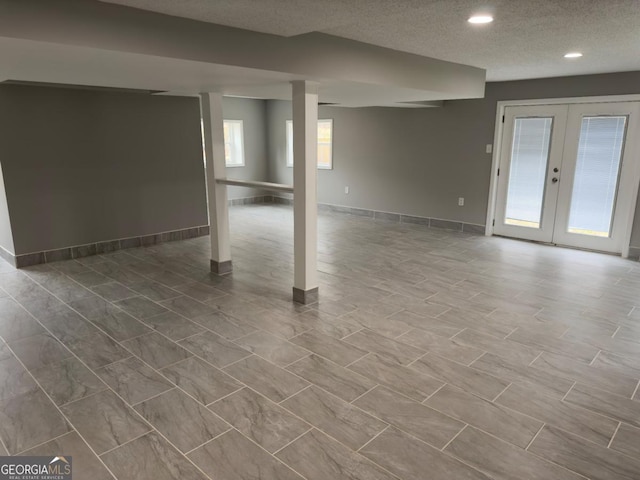 basement featuring a textured ceiling and french doors