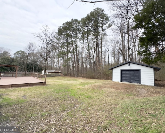 view of yard with a garage, an outdoor structure, and a deck