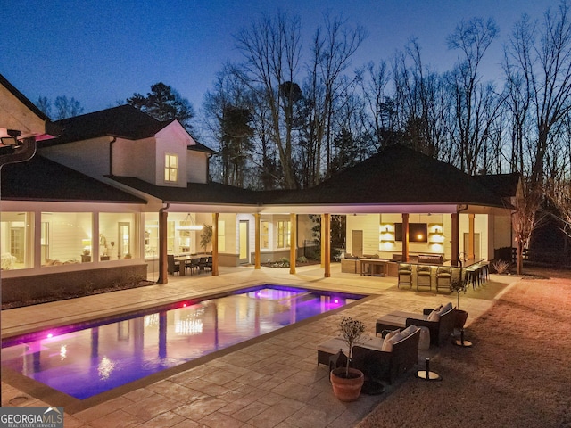 view of swimming pool featuring exterior kitchen, a patio, and an outdoor bar