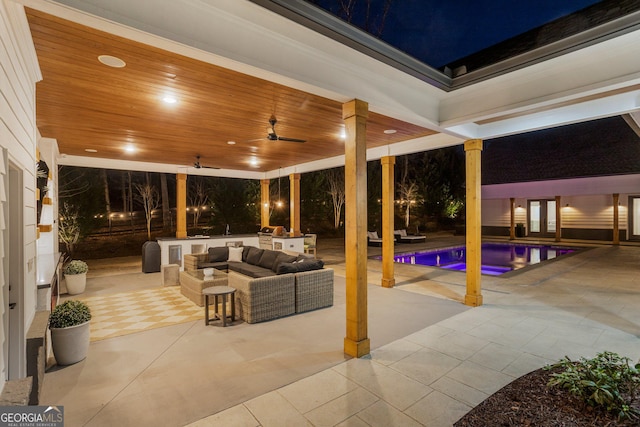 patio at night featuring outdoor lounge area and ceiling fan