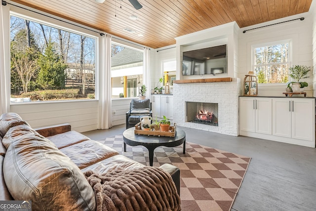 sunroom / solarium with a brick fireplace, a wealth of natural light, and wooden ceiling