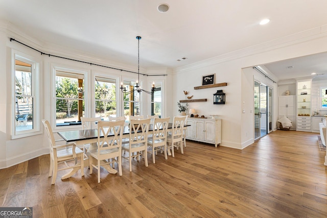 dining area featuring ornamental molding, plenty of natural light, and light hardwood / wood-style flooring