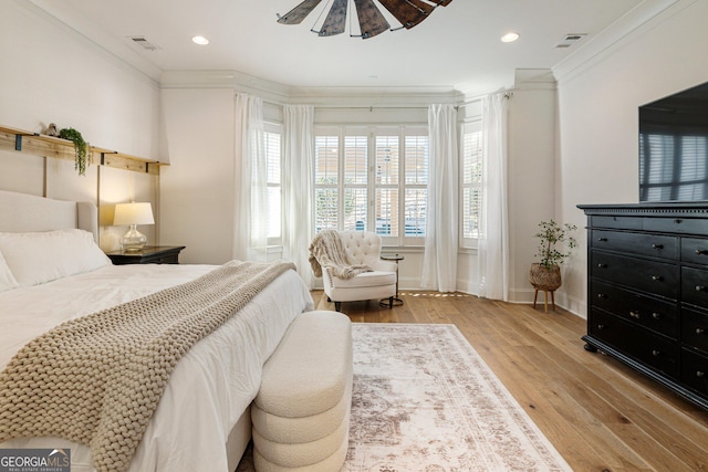 bedroom with crown molding, light hardwood / wood-style flooring, and ceiling fan