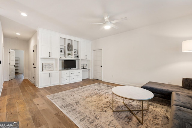 living room with ceiling fan and light wood-type flooring