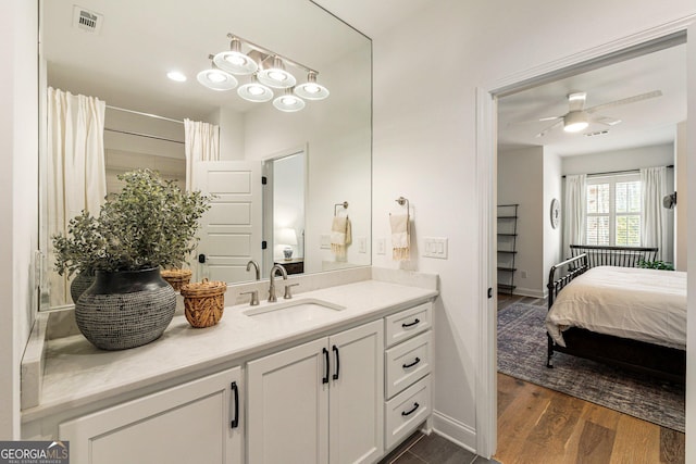 bathroom with wood-type flooring, vanity, ceiling fan, and walk in shower