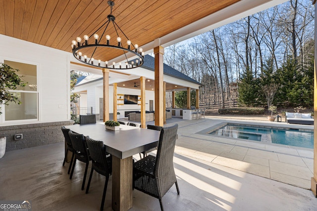 exterior space featuring a notable chandelier, a healthy amount of sunlight, concrete flooring, and wooden ceiling