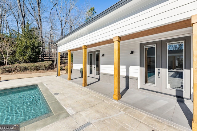 view of swimming pool with a patio and french doors