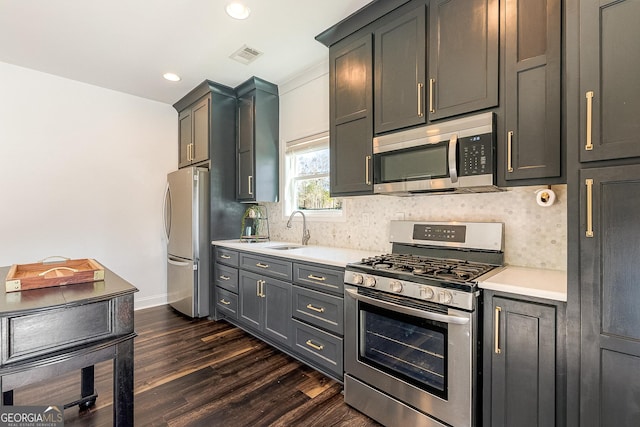 kitchen featuring sink, gray cabinets, backsplash, stainless steel appliances, and dark hardwood / wood-style floors