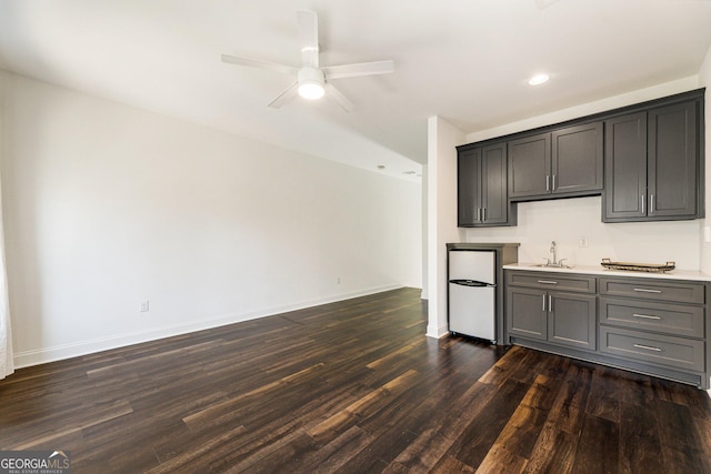 kitchen featuring ceiling fan, sink, and dark hardwood / wood-style floors