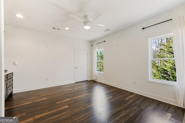 unfurnished room featuring ceiling fan and dark hardwood / wood-style flooring