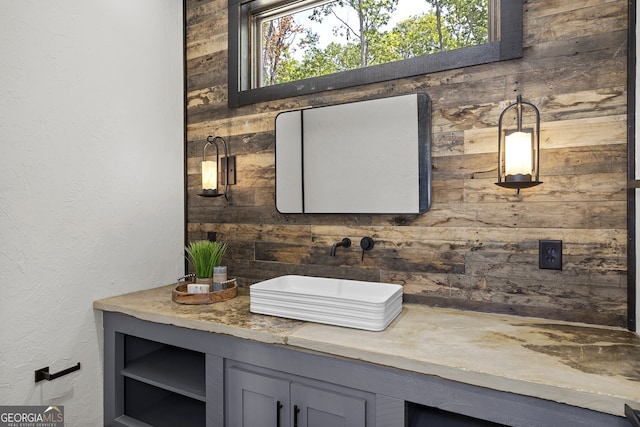 bathroom featuring vanity and wood walls