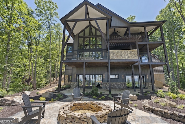 rear view of house featuring a patio, ceiling fan, and an outdoor fire pit