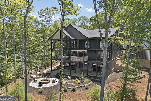 rear view of house with a patio, a balcony, and a fire pit