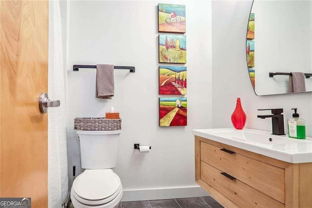 bathroom with tile patterned floors, baseboards, toilet, and vanity