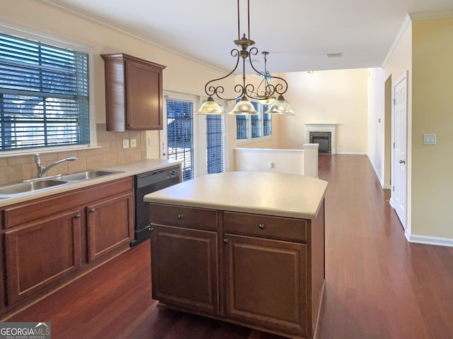 kitchen featuring pendant lighting, dishwasher, sink, dark hardwood / wood-style flooring, and decorative backsplash