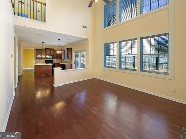 unfurnished living room with ceiling fan and dark hardwood / wood-style floors