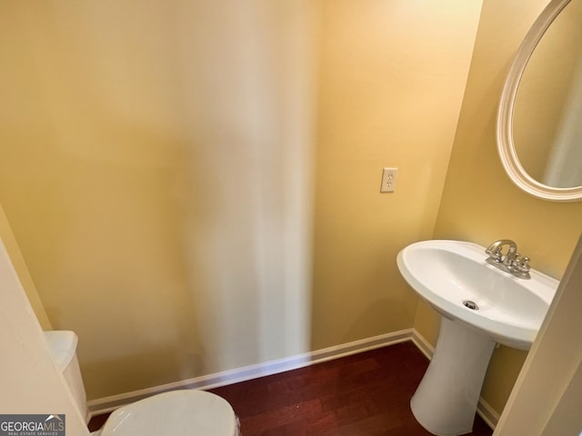 bathroom featuring wood-type flooring and toilet