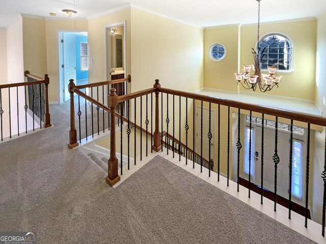 corridor featuring a notable chandelier, carpet floors, and ornamental molding