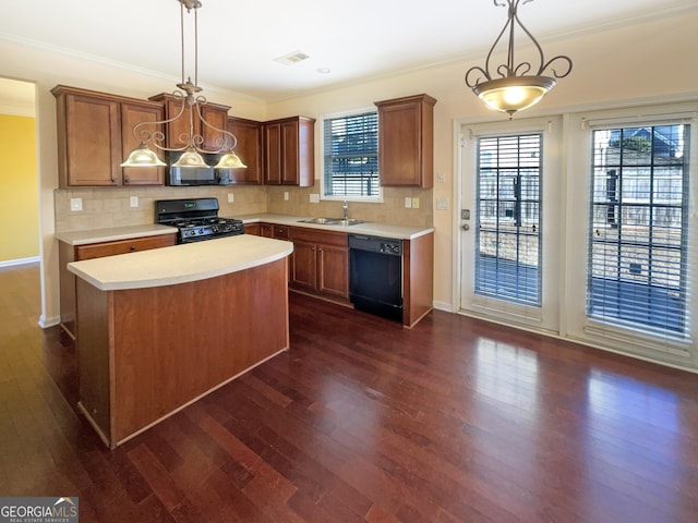 kitchen with sink, dark wood-type flooring, a center island, black appliances, and decorative light fixtures