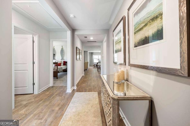 corridor with light hardwood / wood-style floors