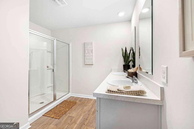 bathroom featuring wood-type flooring, an enclosed shower, and vanity