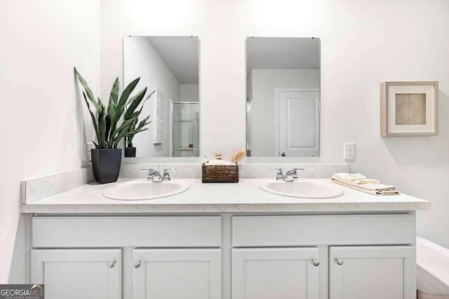 bathroom featuring a shower with door and vanity