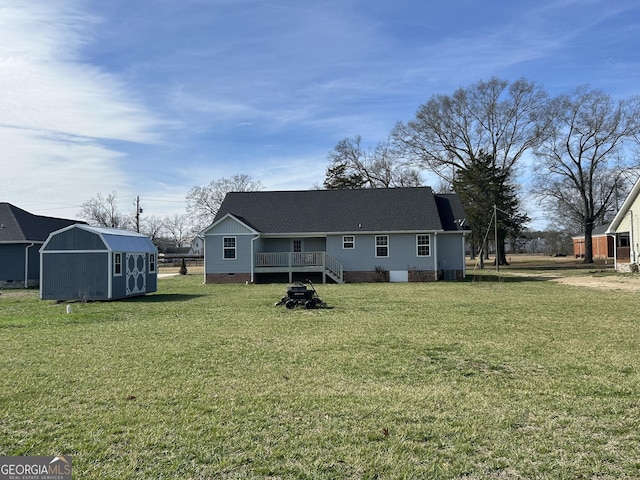 rear view of property featuring a yard and a storage unit