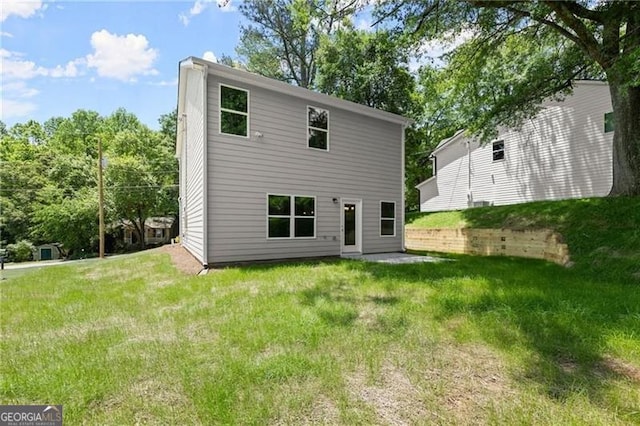 back of house with a lawn