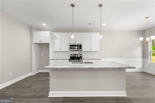 kitchen featuring light stone countertops, appliances with stainless steel finishes, and pendant lighting