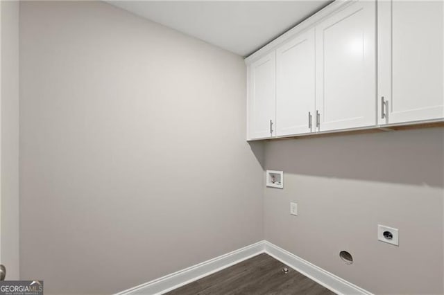 clothes washing area with electric dryer hookup, hookup for a washing machine, dark wood-type flooring, and cabinets