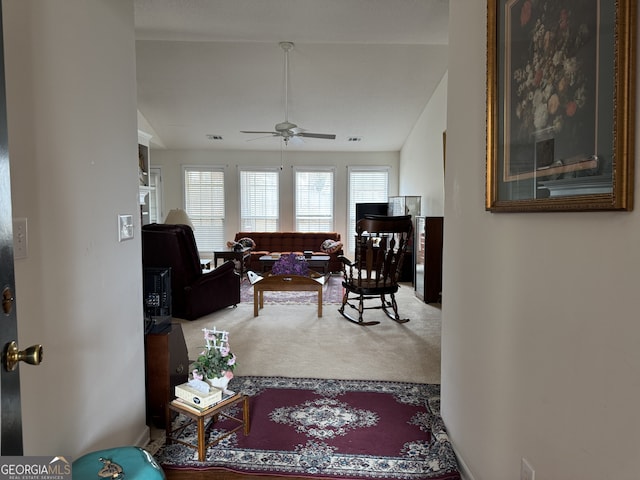 living room featuring vaulted ceiling, carpet flooring, and ceiling fan