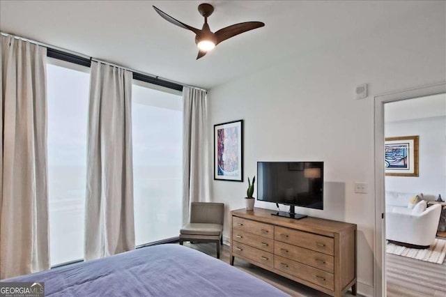 bedroom featuring wood-type flooring, ceiling fan, and baseboard heating