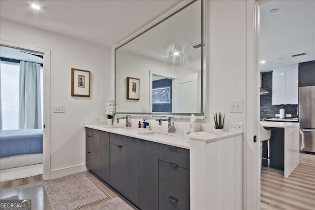 bathroom with tasteful backsplash, vanity, and hardwood / wood-style floors