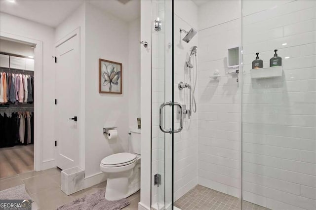 bathroom featuring toilet and a shower with door