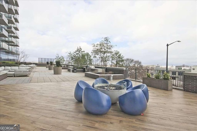 deck featuring an outdoor living space with a fire pit