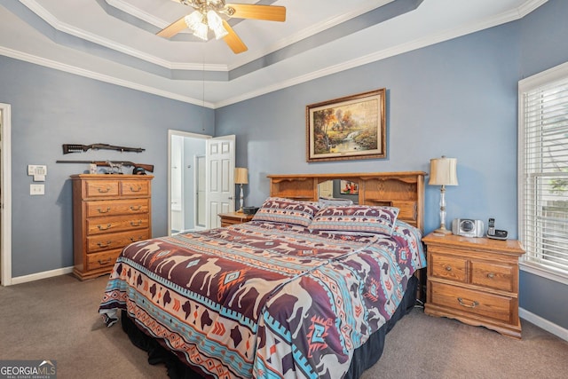 bedroom with ceiling fan, baseboards, ornamental molding, a tray ceiling, and carpet