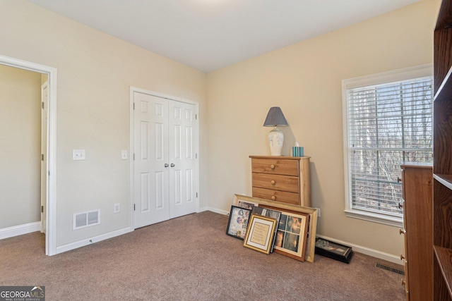 carpeted bedroom with baseboards, visible vents, and a closet