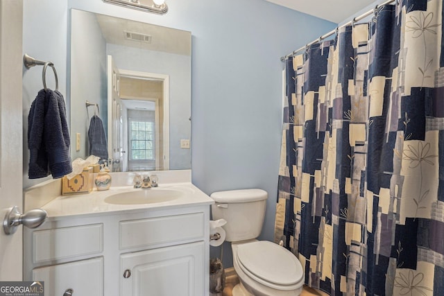 bathroom with toilet, curtained shower, visible vents, and vanity