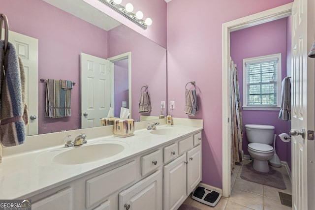 bathroom featuring double vanity, tile patterned flooring, a sink, and toilet