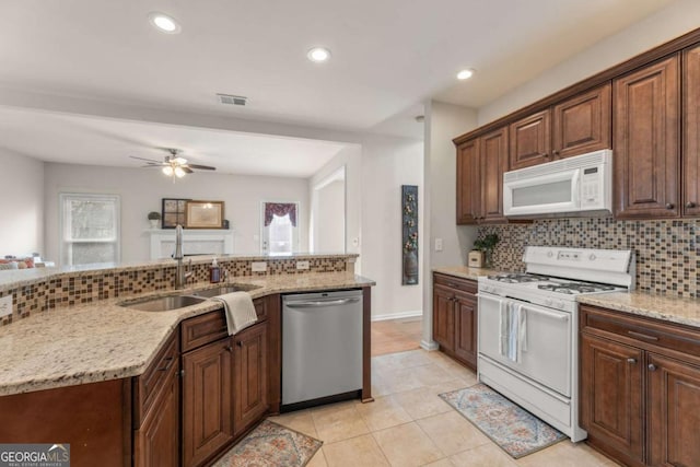 kitchen featuring light stone counters, white appliances, and decorative backsplash