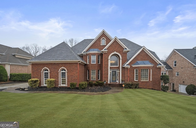 view of property with a garage and a front lawn