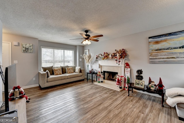 living room with wood-type flooring, a textured ceiling, and ceiling fan