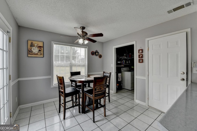 dining area with light tile patterned flooring, washer / dryer, a textured ceiling, and ceiling fan