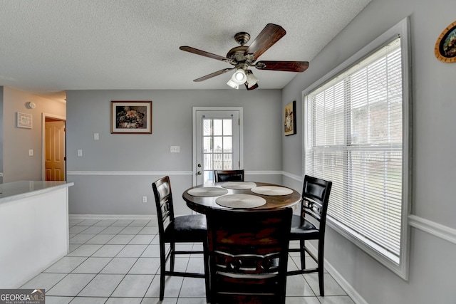 dining room with ceiling fan, a textured ceiling, and light tile patterned flooring