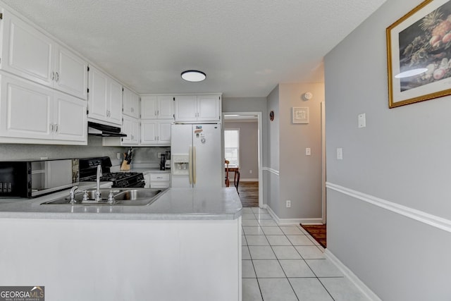 kitchen with sink, light tile patterned floors, black range, white refrigerator with ice dispenser, and white cabinets