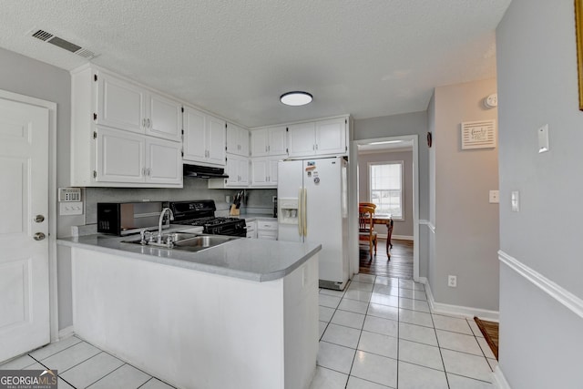 kitchen with white cabinets, black stove, kitchen peninsula, and white fridge with ice dispenser